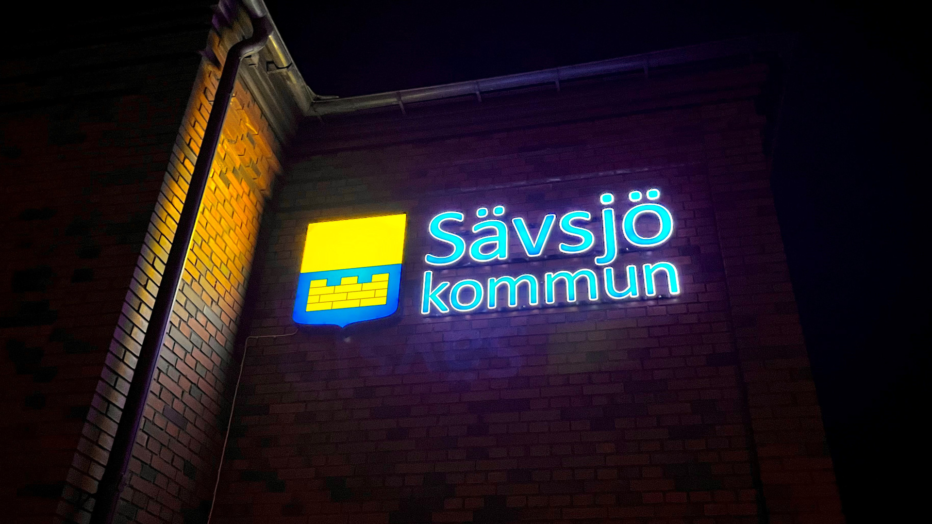 Sävsjö kommuns logotyp i form av en ljusskylt som sitter på Kommunalhusets fasad. 
