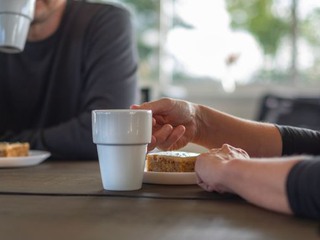 två personer vid bord dricker kaffe